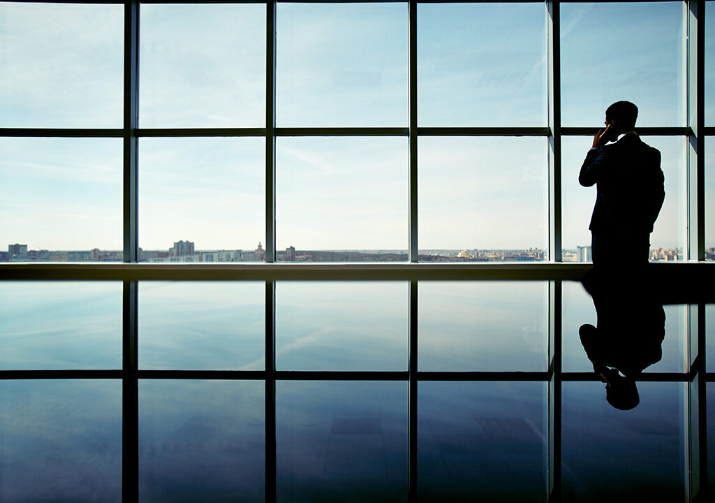 Outline of office worker speaking on the phone by the window
